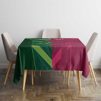 Green and magenta patterned tablecloth covering dining table with four chairs
