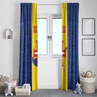 Pair of blue curtains with yellow panels and flag-style print, set in doorway.