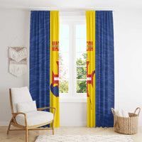 Blue and yellow window curtains with flag-style graphic, hanging in living room.