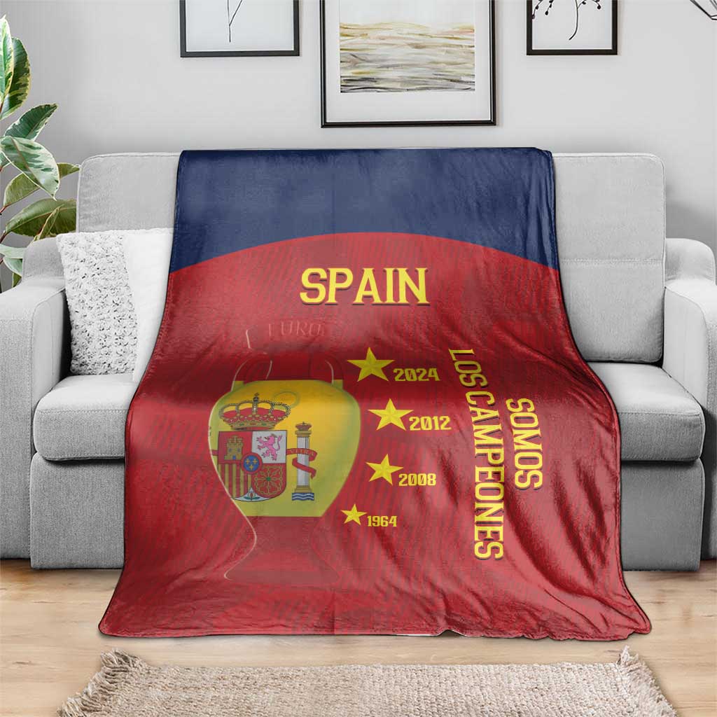 Spain football blanket on sofa, red and navy design with SPAIN, crest, and 'Los Campeones'