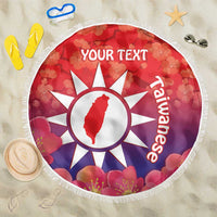 Round red beach blanket with white sun emblem, pink blossoms and 'YOUR TEXT', fringed edge.
