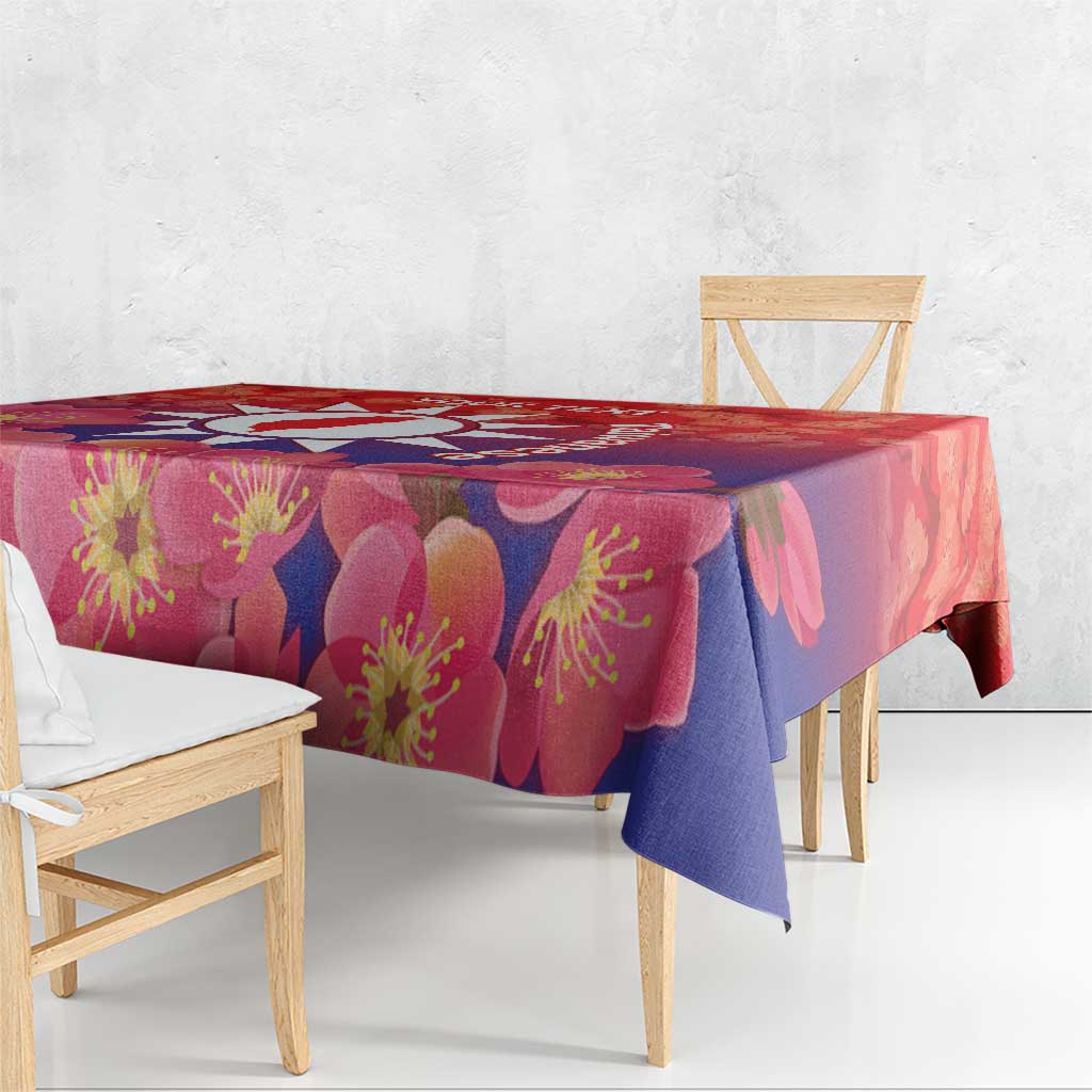 Red floral tablecloth with pink and purple blossoms draped over a dining table