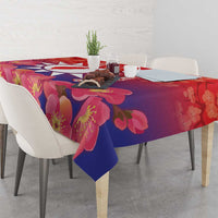 Red floral tablecloth with pink blossoms and deep blue accents on a dining table