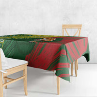 Green and red patterned tablecloth draped over wooden bench and table