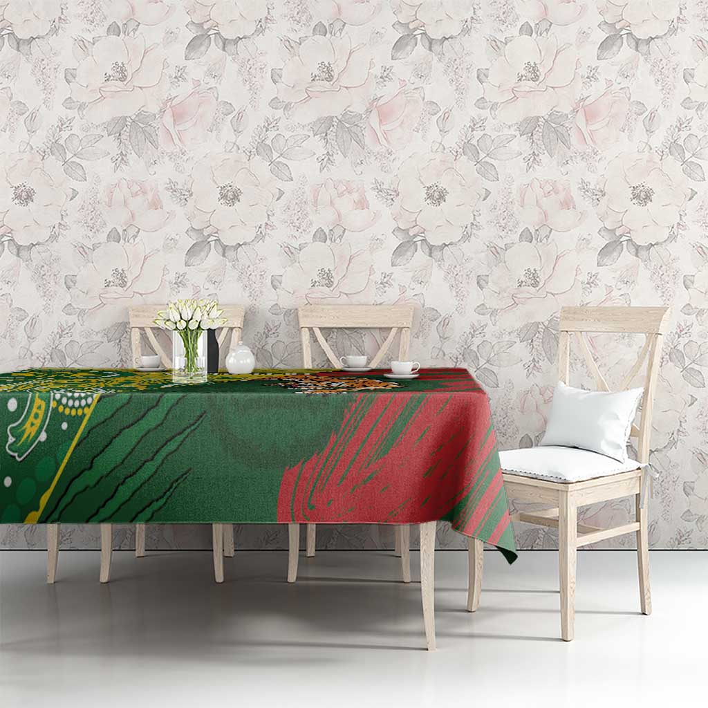 Green and red patterned tablecloth on dining table with white chairs