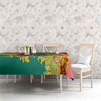 Tablecloth on dining table featuring green-and-yellow flag side and red leafy design