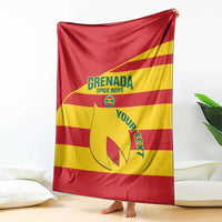 Grenada football blanket draped on sofa, red and yellow stripes with crest graphic