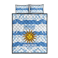 Blue and white quilt and two pillow shams with Uruguay crest and sun graphic