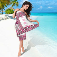 Pink folk patterned sarong wrap with magenta geometric bands and fringe at edge