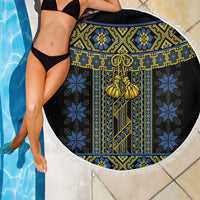 Round black beach blanket with blue and gold vertical folk pattern and white braided rope fringe