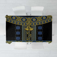 Black tablecloth with blue and yellow geometric folk pattern, rope-style border.