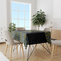 Tablecloth draped on dining table, black base with blue and yellow geometric pattern.