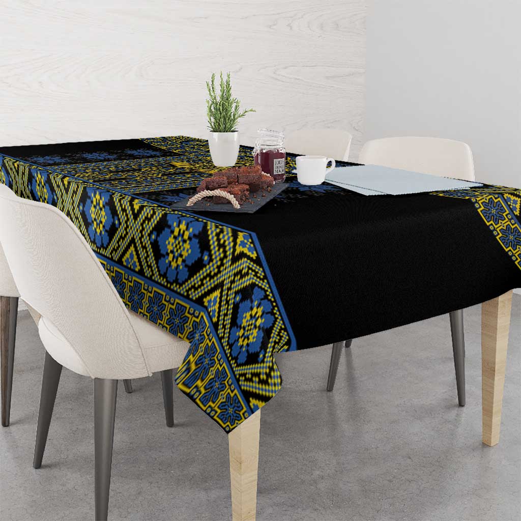 Geometric folk tablecloth on dining table: black fabric with blue and yellow trim.