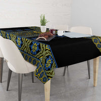 Geometric folk tablecloth on dining table: black fabric with blue and yellow trim.