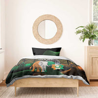 Black bedding set on bed with elephant graphic, green curves, and gold tribal design