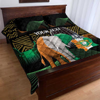 Black quilt bed set with large elephant design, green waves, orange-gold curves, and pillows