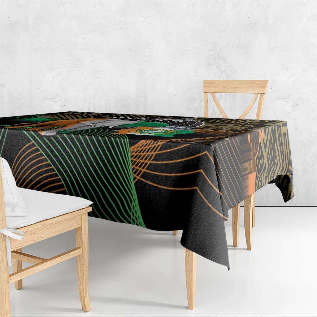 Black tablecloth with green and gold geometric stripes and elephant-themed graphic, draped