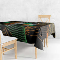 Black tablecloth with green and gold geometric stripes and elephant-themed graphic, draped