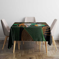 Black square tablecloth with green and gold African geometric design, elephant crest center