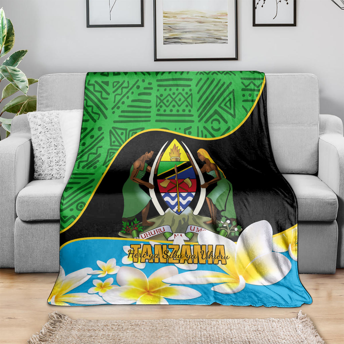 Green, black, and blue Tanzania-themed blanket draped over a sofa, featuring an emblem and plumeria