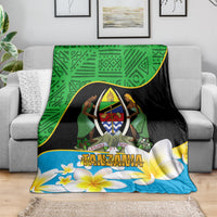 Green, black, and blue Tanzania-themed blanket draped over a sofa, featuring an emblem and plumeria
