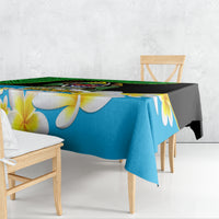 Blue and black tablecloth with large white-and-yellow flowers and green patterned edge