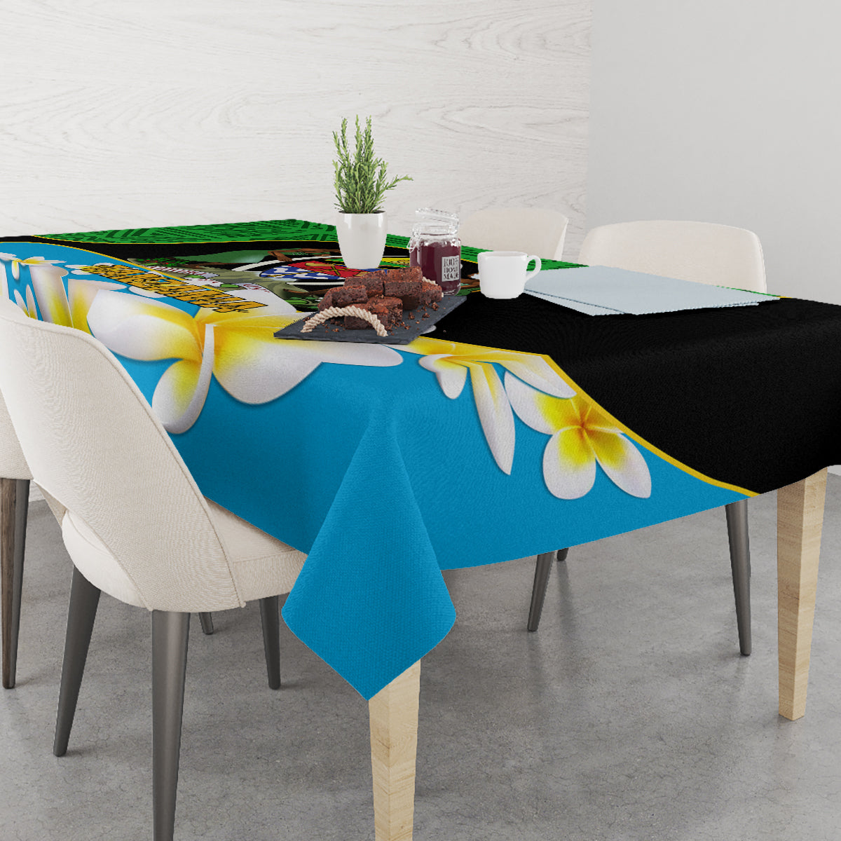 Blue tablecloth with white and yellow flower print draped over dining table and green border
