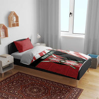 Red, white, and black bedding set on bed with shield duvet graphic and red patterned pillows