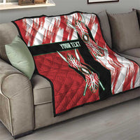 Red quilt blanket on gray sofa, featuring tribal emblems, black band, and "Your Text".