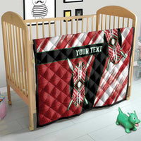 Red quilt on wooden baby bed frame, black band with "Your Text" and tribal emblem design.
