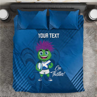 Blue duvet cover set with two pillows, thistle mascot graphic and 'YOUR TEXT' on bedding