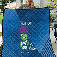 Blue quilt blanket with diamond stitching, 'YOUR TEXT' and green thistle mascot