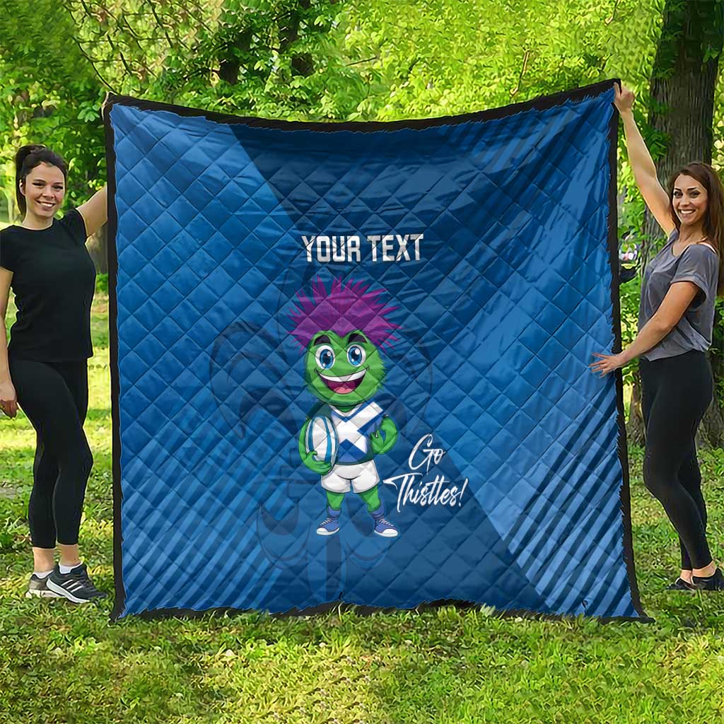 Blue quilt blanket outdoors with 'YOUR TEXT' and green thistle mascot graphic