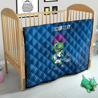 Blue quilt blanket on a toddler bed with 'YOUR TEXT' and green thistle mascot