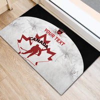 Custom Canada hockey doormat on floor: black edge, white maple leaf, red “YOUR TEXT”