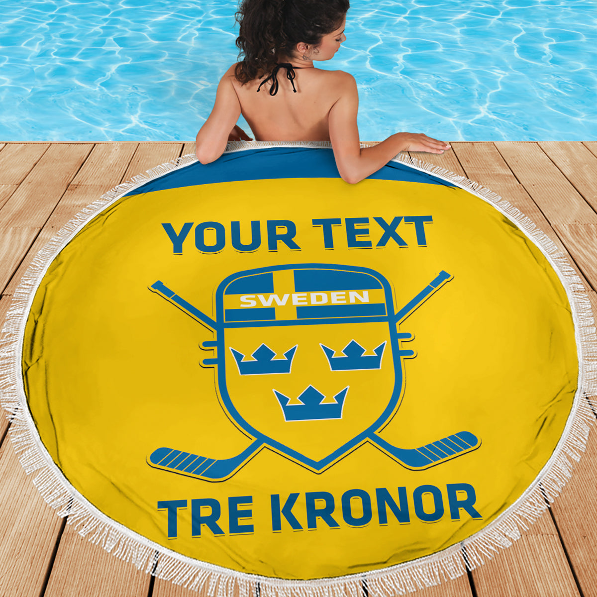 Yellow round beach blanket with fringe, Sweden crest and 'TRE KRONOR' near pool