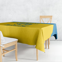 Yellow tablecloth with blue edge, draped over dining table with wide overhang