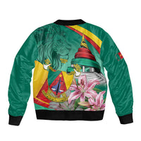 Green bomber jacket with ribbed hem, large crest and lily-style floral graphic