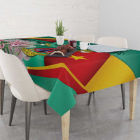 Green tablecloth with red, yellow, and green geometric emblem and pink flower details