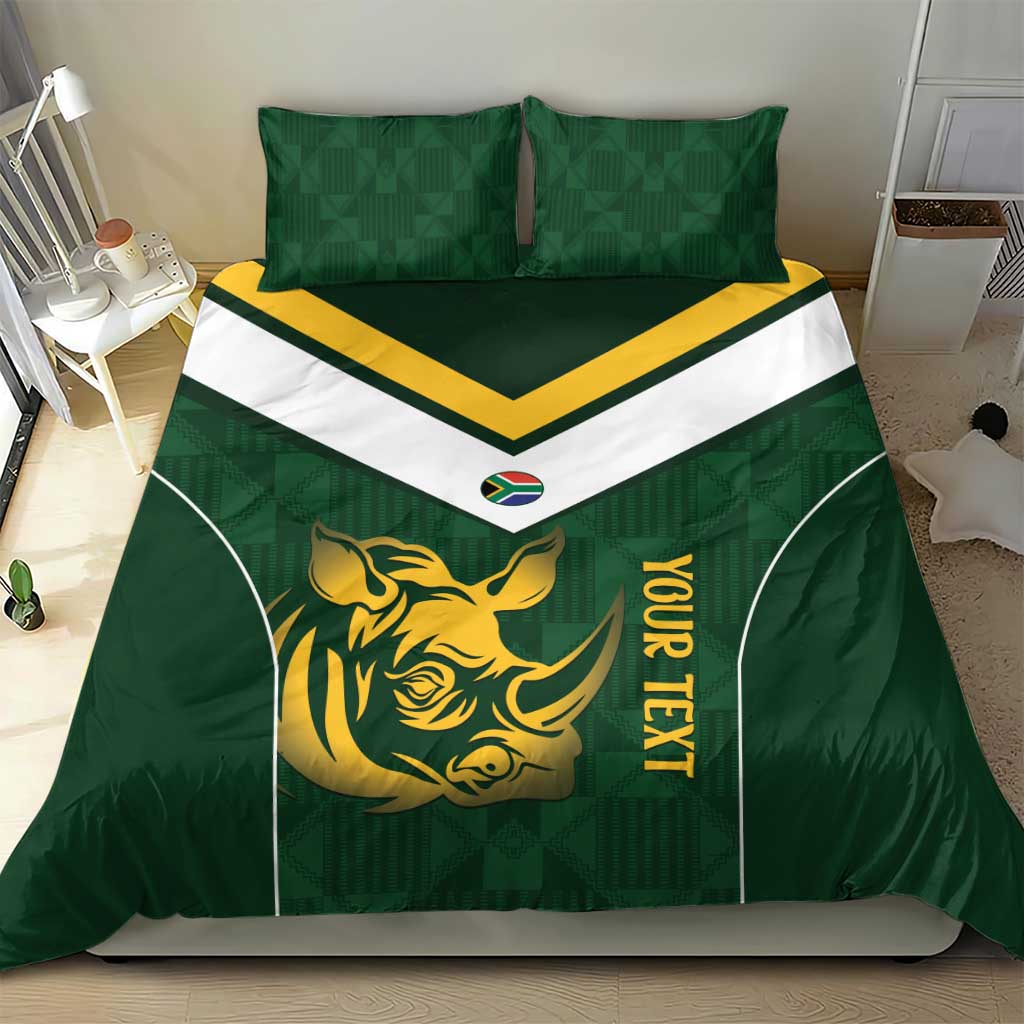 Green duvet cover with gold rhino symbol, yellow vertical text, white chevron panel, two pillows