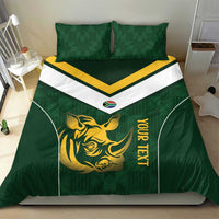 Green duvet cover with gold rhino symbol, yellow vertical text, white chevron panel, two pillows