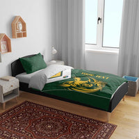 Green duvet cover with gold rhino design and yellow text strip, styled on a bed
