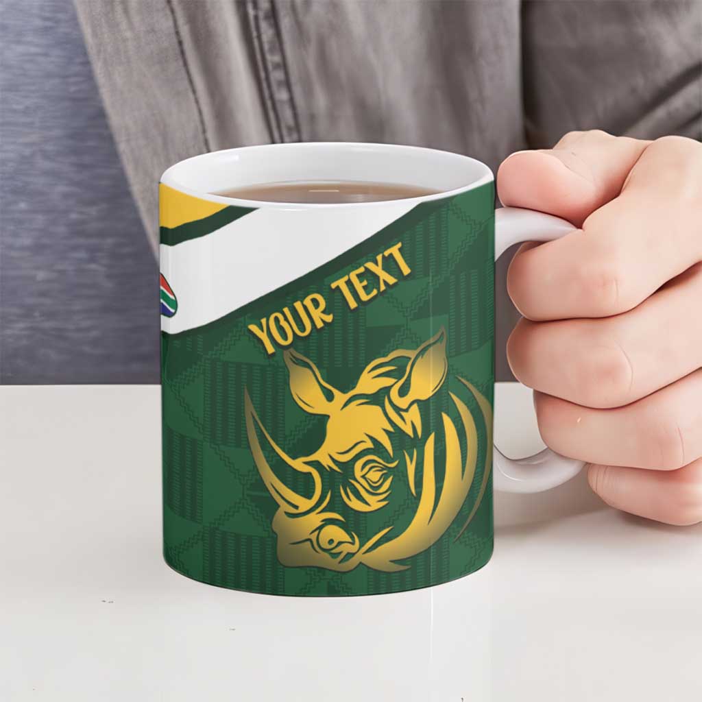 Green ceramic mug held by hand with gold rhino and “YOUR TEXT” graphic