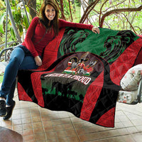 Kenya safari quilt laid on couch with red border, green center, lions, 'KENYA PROUD' emblem