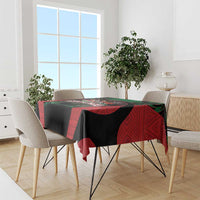 Safari themed tablecloth draped over dining table, red and black with green accents and animal graphic
