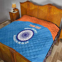 Blue quilt over bed with orange border, quilted texture, India cricket women emblem