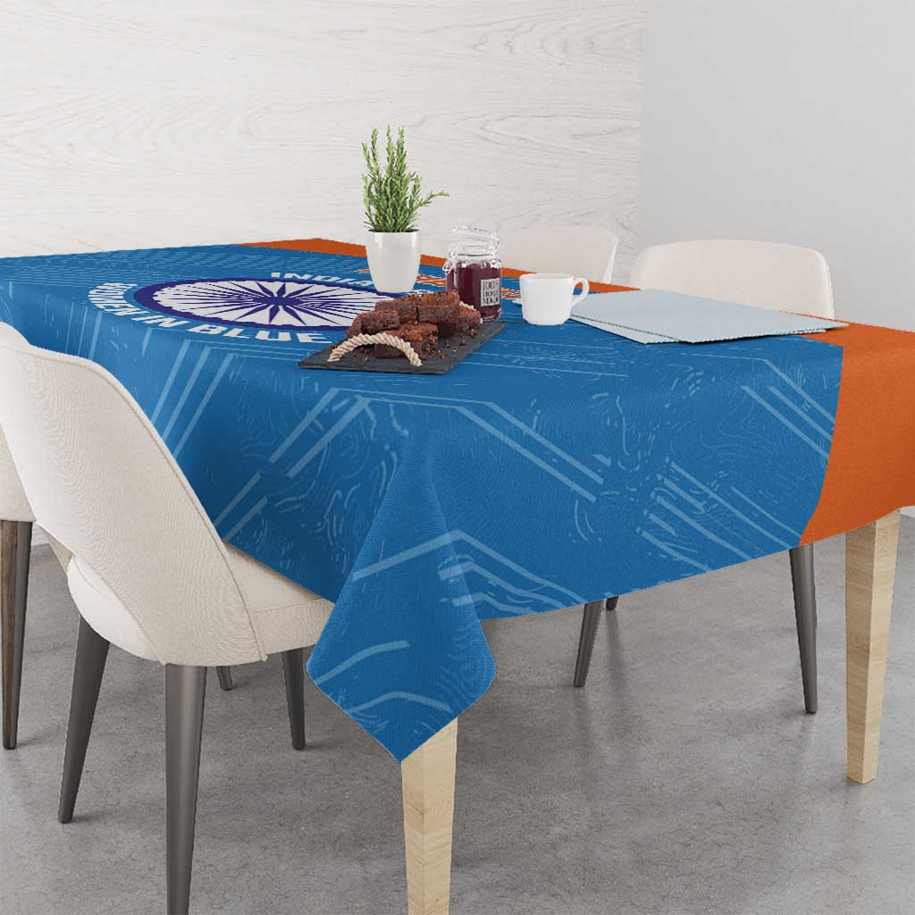 Blue cricket tablecloth draped over dining table with circular India women logo