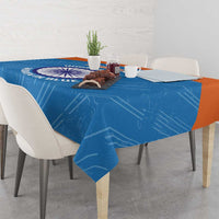 Blue cricket tablecloth draped over dining table with circular India women logo