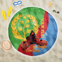 Green round beach blanket with white fringe, featuring tree graphic and “One People One Heart”