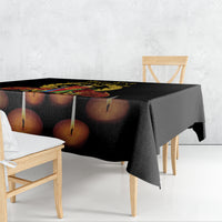 Black tablecloth with printed candle design draped over a dining table